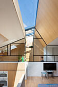Modernes Wohnzimmer mit Holzelementen und Glasdach