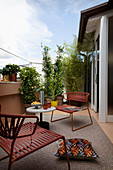 Outdoor-Sessel und Tisch auf PVC-Teppich auf der Terrasse