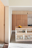 Kücheninsel in offener Küche mit Einbaumöbeln aus hellem Holz