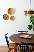 Arrangement of three baskets on wall above round table and spoke-back chairs