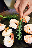 Prawns being fried with rosemary