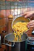 Dropping pasta into boiling water