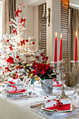 Festively set table and Christmas tree decorated in red and white