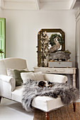 A light day bed with an animal fur, a drawer unit and a wall mirror in a living room