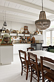 A dining table with chairs in an open-plan, shabby-chic style kitchen