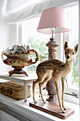 A stuffed fawn on a windowsill