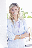 A young blonde woman wearing a purple t-shirt and a blue-and-white striped shirt