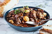 Beef Bourguignon garnished with fresh lemon thyme and served with homemade artisan bread