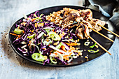 Satay with peanut sauce and red cabbage salad in Thai style
