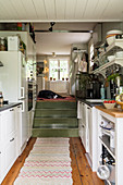 Wooden stairs leading to a narrow kitchen with open shelves