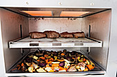 Meat and oven-roasted vegetables being grilled in a Beefer