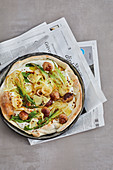Savoury tarte flambé with oriental sausages, onions and bok choy