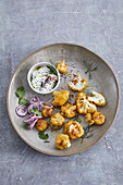 Baked cauliflower bahjis in a coriander coating with a dill and yoghurt dip