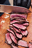 Cutting grilled flank steak into strips