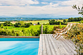 Deckchair at poolside with a view of the surrounding countryside