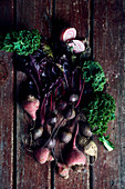 Golden beets, chioggia beets and beetroots with kale on a wooden surface