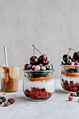 Dessert in a jar with raspberries blueberries cherries and peanut butter