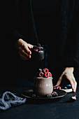 Fruit dessert in a jar with frozen raspberries and blackberries