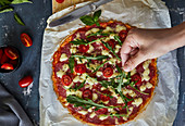 Keto-Pizza mit Salami, Mozzarella, Tomaten und Rucola