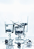 Stem glasses with splash of drink and blue berries