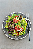 Spring salad with goat cheese wrapped in bacon