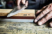 A knife being sharpened on a whetstone