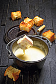 Outdoor cheese fondue in a Dutch oven