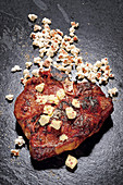 A Porterhouse steak with salted popcorn and passion fruit and gin butter