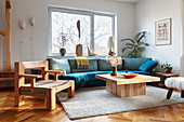 A blue upholstered sofa, a wooden coffee table and a designer chair