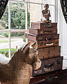 Filipino papier mache horse next to collection of vintage travel and writing cases