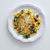 Sea bass fillets with citrus fruits, olives and capers