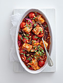 Hake with tomatoes, olives and pine nuts