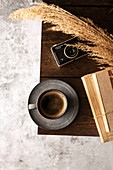 Eine Tasse Kaffee, Fotoapparat, Ähre und Bücher