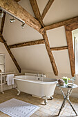 Frei stehende Badewanne und Beistelltisch im Bad im restaurierten Bauernhaus