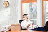 Businessman relaxing at desk in office