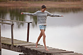 Woman walking on dock over lake