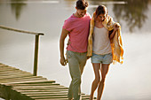 Couple walking on dock over lake