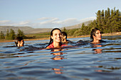 Smiling friends swimming in lake