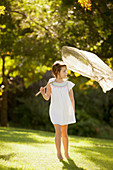 Girl carrying butterfly net in grass
