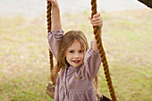 Portrait of smiling girl on swing