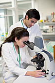 Scientists using microscope