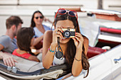 Woman taking picture from convertible