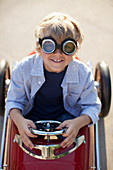 Boy wearing goggles in go cart