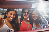 Smiling women driving convertible
