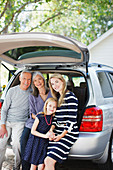Family sitting in trunk of car