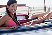 Smiling woman relaxing in convertible
