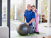 Girl hugging grandfather on exercise ball