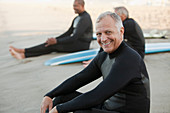 Older surfers sitting on boards on beach