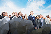 Crowd of business people with umbrellas