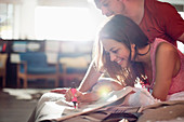 Couple reading newspaper together on bed